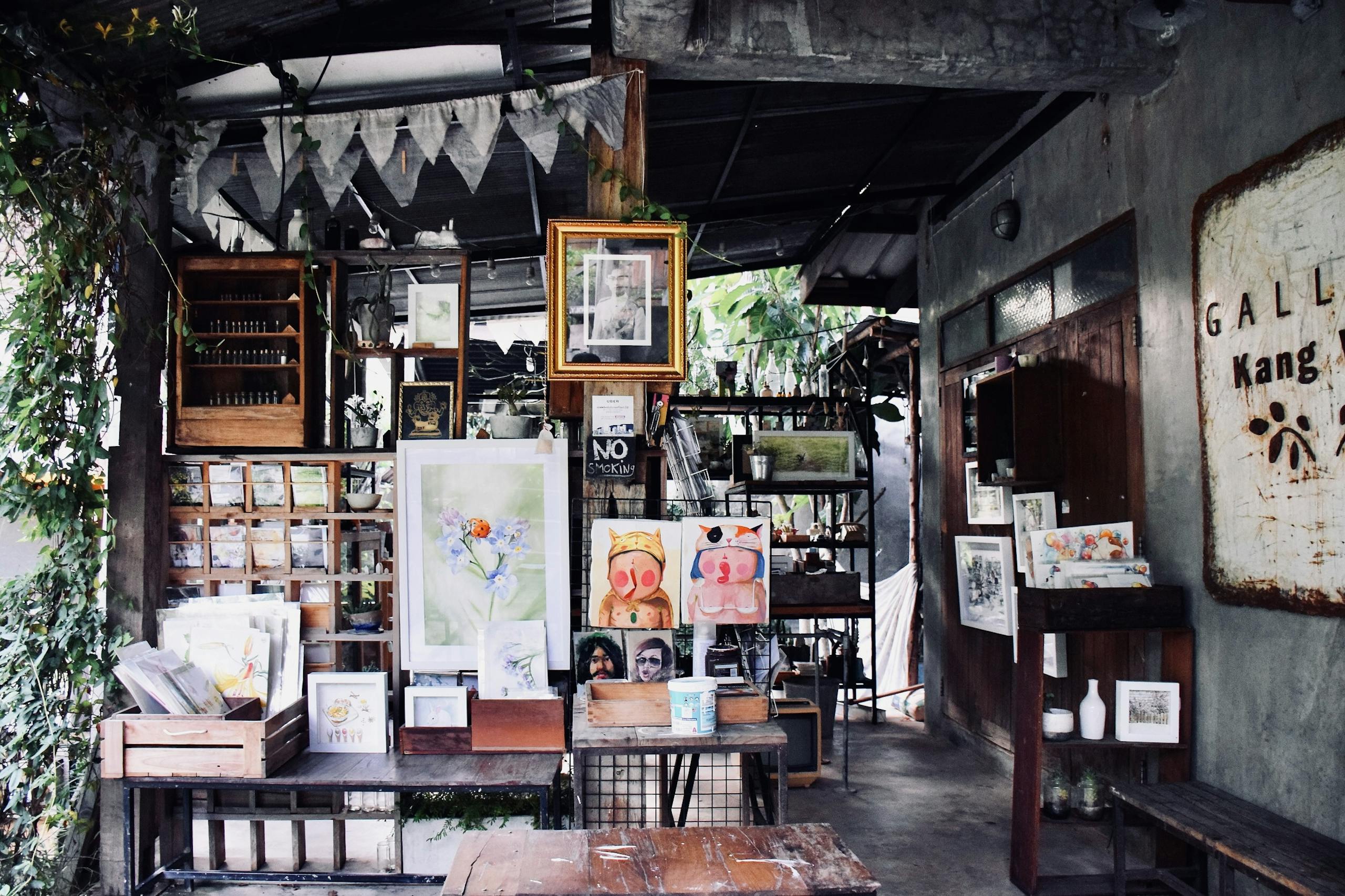 Art studio with diverse paintings and prints on display in a charming rustic setting.