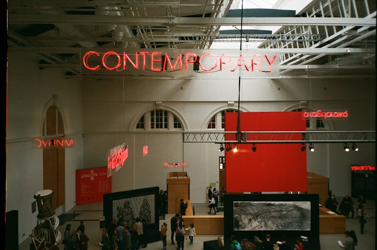 View of a contemporary art exhibition in a modern gallery, showcasing unique displays and architecture.